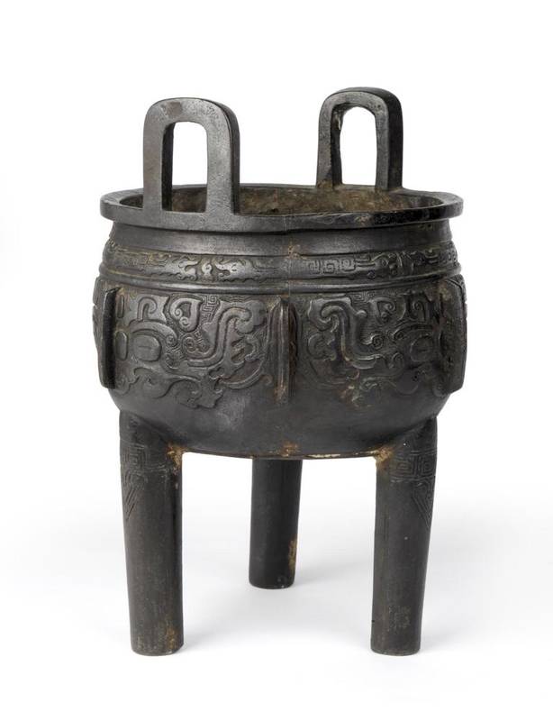 Lot 123 - A Chinese Bronze Ding, of archaic form, with loop handles, the ovoid body cast with Taotie on three