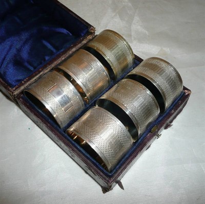 Lot 275 - Set of six silver plated napkin rings, cased