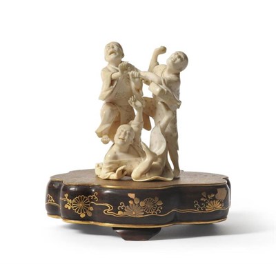 Lot 127 - A Japanese Ivory Figure Group, Meiji period, as three fighting figures, one holding a musical...