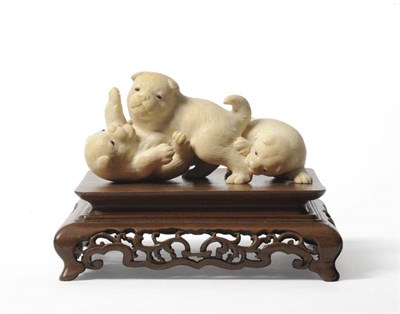 Lot 128 - A Japanese Ivory Okimono, Meiji period, as three puppies play fighting, with glass eyes,...