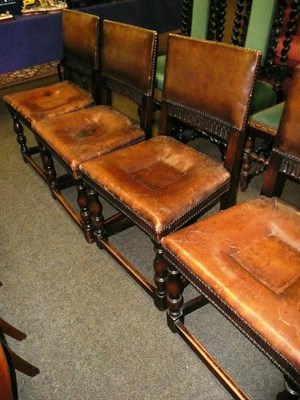 Lot 562 - A set of four oak framed leather upholstered dining chairs