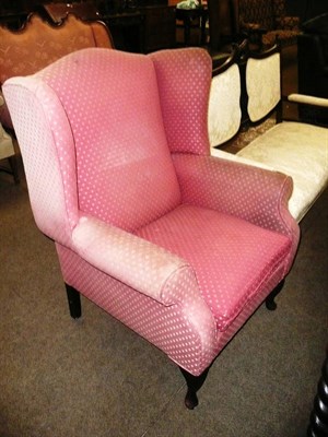 Lot 567 - An upholstered wing back arm chair