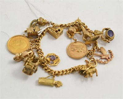 Lot 82 - A curb bracelet hung with fifteen charms including a 1913 loose mounted full sovereign