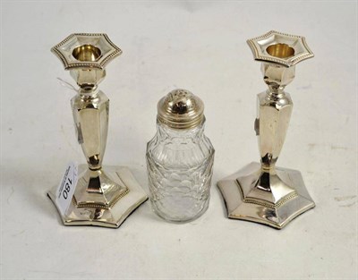 Lot 180 - Pair of loaded silver candlesticks and a silver-topped pepperette (3)