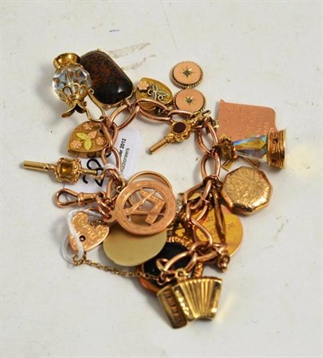 Lot 226 - A charm bracelet hung with eighteen charms, with swivel catch and padlock