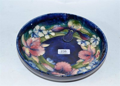 Lot 238 - William Moorcroft pottery bowl decorated with orchids on a blue ground