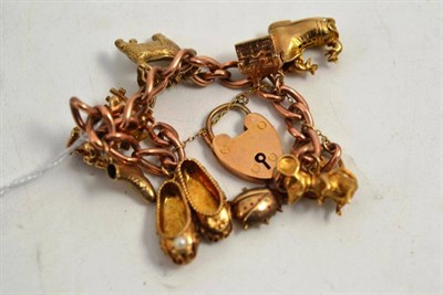 Lot 268 - A 9ct gold charm bracelet suspended with eleven charms including a Ladybird, mouse with swivel...