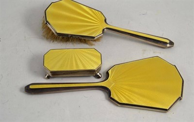 Lot 359 - A silver and yellow guilloche enamel backed three piece vanity set