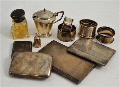 Lot 414 - A silver mustard pot, five silver napkin rings, three silver cigarette cases, a silver match...