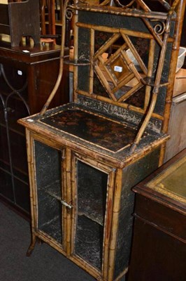 Lot 551 - A small bamboo framed glazed cabinet with mirror back