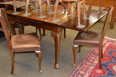 Lot 566 - An oak draw leaf dining table and six chairs with leather backs and seats