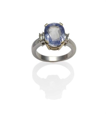 Lot 237 - A Sapphire and Diamond Three Stone Ring, the oval mixed cut cornflower blue coloured sapphire...