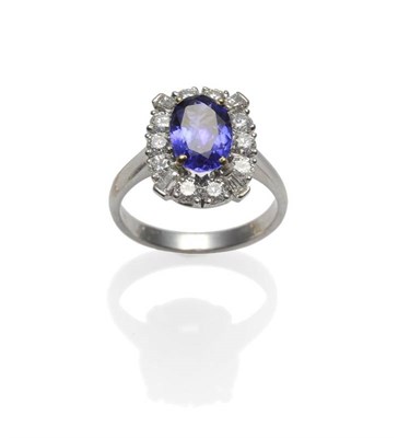 Lot 239 - An 18 Carat White Gold Tanzanite and Diamond Cluster Ring, the oval cut tanzanite within a...
