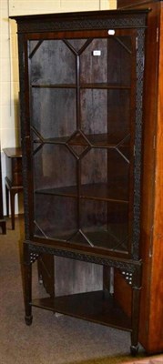 Lot 627 - An Edwardian corner cabinet with blind fret carved decoration