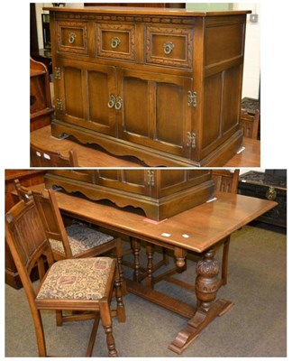 Lot 629 - A reproduction oak dining suite comprising a refectory table, four chairs, a side table and...