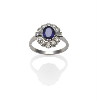Lot 243 - A Sapphire and Diamond Cluster Ring, the oval mixed cut sapphire within a border of round brilliant
