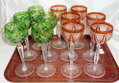 Lot 11 - A set of six orange tint hock glasses and a set of five green tint hock glasses