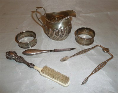 Lot 72 - Edwardian embossed silver cream jug, unusual Scottish Victorian sugar tongs, two napkin rings and a