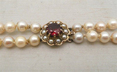 Lot 102 - Two strand pearl necklace with gold and garnet clasp