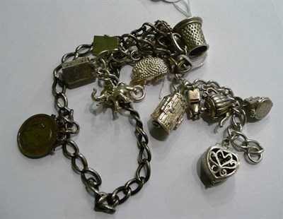 Lot 111 - A silver charm bracelet hung with eleven charms and a silver Albert hung with a half sovereign