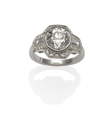 Lot 274 - A Diamond Ring, a brilliant cut diamond within an Art Deco style frame, with baguette cut...