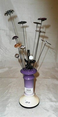 Lot 355 - Twelve various hatpins in a pottery hatpin stand