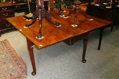 Lot 468 - A solid yew wood top dining table on cabriole legs