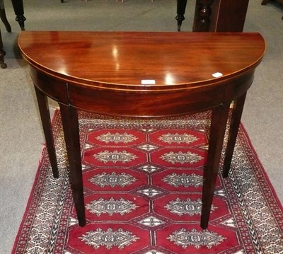 Lot 490 - A George III mahogany fold-over card table