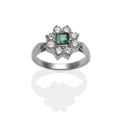 Lot 306 - An Emerald and Diamond Cluster Ring, the step cut emerald within a border of eight round...