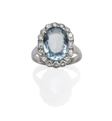 Lot 314 - An 18 Carat White Gold Aquamarine and Diamond Cluster Ring, an oval cut aquamarine within a...