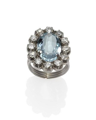 Lot 321 - An Aquamarine and Diamond Cluster Ring, the oval cut aquamarine within a spaced border of old...