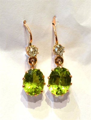 Lot 325 - A Pair of Diamond and Peridot Drop Earrings, circa 1900, an old cut diamond suspends an oval...