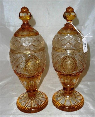 Lot 33 - A pair of amber flask glass vases and covers