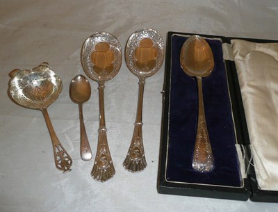 Lot 35 - A cased silver spoon, pair of silver serving spoons, a tea strainer and a tea spoon