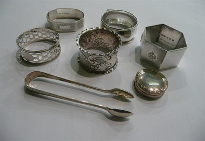 Lot 68 - Five silver napkin rings, tongs and a hinged pill box