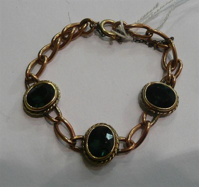 Lot 79 - A curb link bracelet with green stones