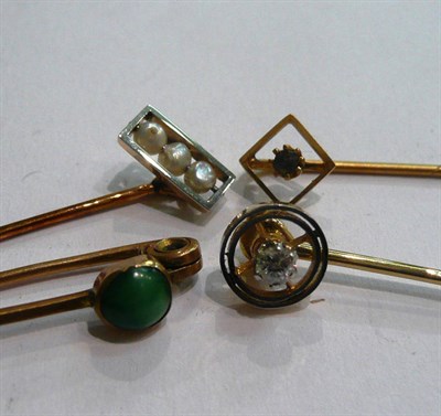 Lot 88 - An early 20th century diamond set stick pin and three other pins