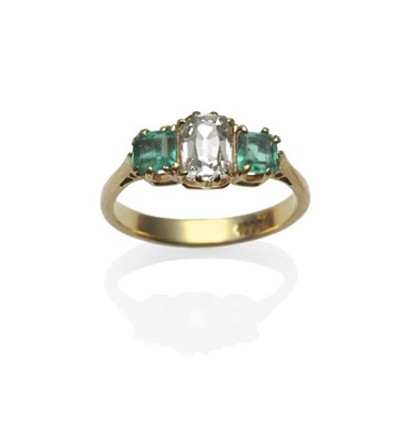 Lot 342 - A Diamond and Emerald Three Stone Ring, the old cut diamond flanked by a step cut emerald on...