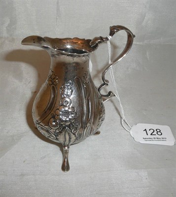 Lot 128 - A George III silver cream jug repousse with flowers on tripod feet
