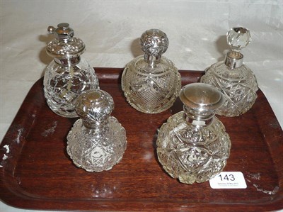 Lot 143 - Four cut glass scent bottles with silver collar and mounts and an atomiser (5)