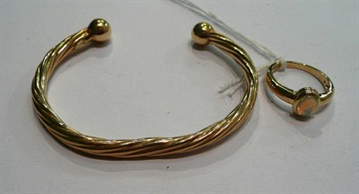 Lot 184 - An 9ct gold twist torque bangle and a 9ct gold opal ring