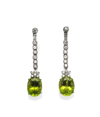 Lot 352 - A Pair of 18 Carat White Gold Peridot and Diamond Drop Earrings, a row of round brilliant cut...