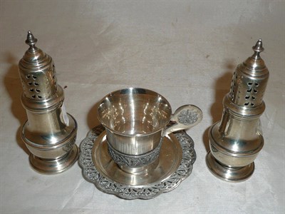 Lot 221 - Pair of silver pepperettes and a cup and saucer (3)