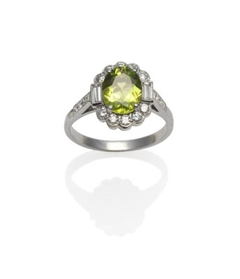 Lot 354 - A Peridot and Diamond Ring, an oval cut peridot within a border of round brilliant cut...