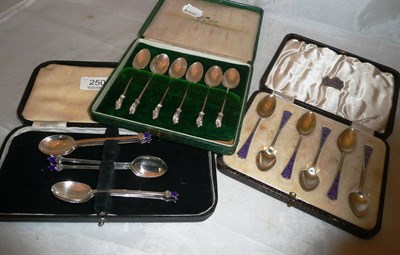 Lot 250 - Three sets of cased silver and enamel spoons