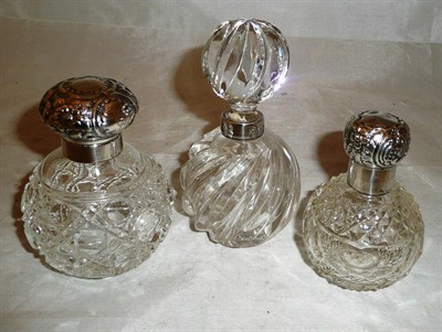 Lot 313 - Three cut glass scent bottles with silver collars and mounts