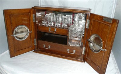 Lot 375 - An Edwardian oak liquor cabinet enclosing decanter and glasses