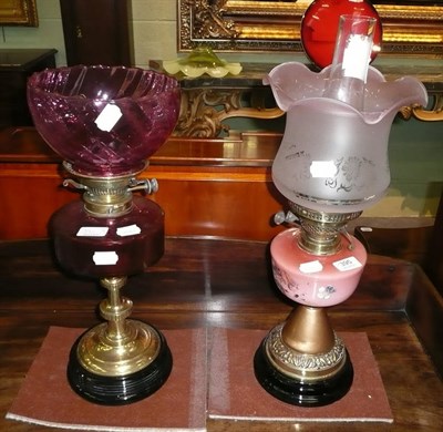 Lot 395 - Cranberry glass oil lamp and shade on brass olumn and an opaque pink glass and painted oil lamp and