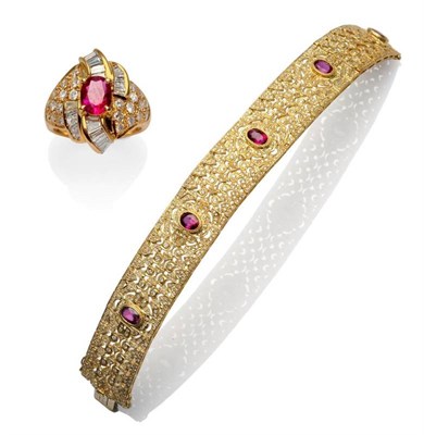 Lot 371 - A Ruby and Diamond Cluster Ring, an oval cut ruby within a spray cluster of baguette cut...