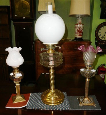 Lot 402 - Oil lamp on turned brass column with clear glass well, chimney and shade and two smaller brass...